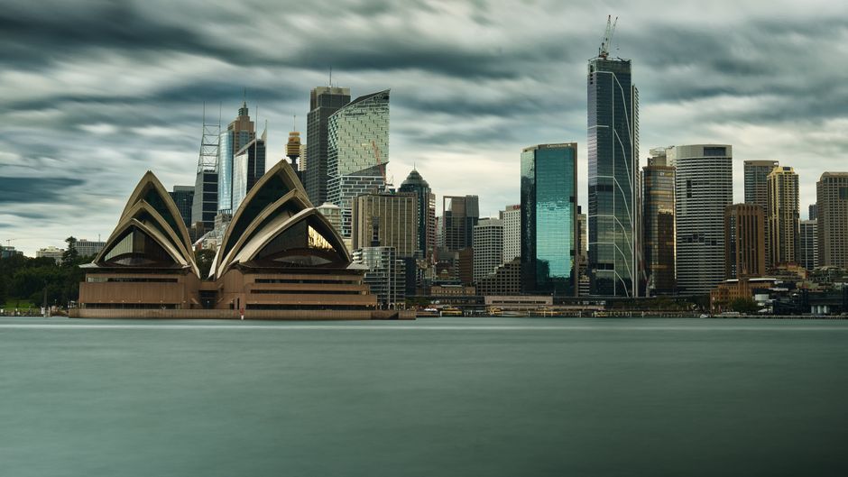 Panoramic view of Sydney's iconic skyline featuring the Sydney Opera House and towering skyscrapers.